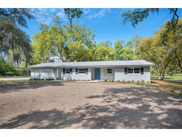 Charming single-story home with updated landscaping and a bright blue front door at 1310 Walt Williams Rd, Lakeland, FL 33809