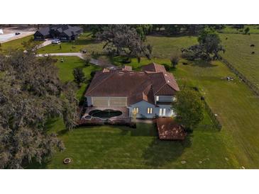 Expansive aerial view of a home with a pool and spacious lawn at 6383 Summertimes Plantation Blvd, Bartow, FL 33830