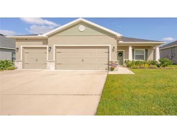 Charming single-story home with a well-maintained lawn and a two-car garage with stone accents at 7289 Liberty Rd, Lakeland, FL 33809