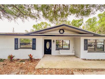 Charming home featuring a brick exterior, black shutters, and a welcoming front porch swing at 135 Kenilwood Ln, Lakeland, FL 33809