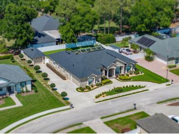 Stunning aerial view of a beige single-Gathering home featuring a well-manicured lawn and circular driveway at 152 Melissa Trl, Auburndale, FL 33823