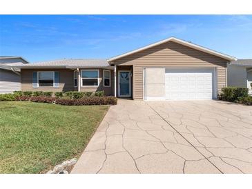 Charming single-story home with well-maintained landscaping, neutral siding, and a two-car garage at 1939 Prairie Dunes N Cir, Lakeland, FL 33810