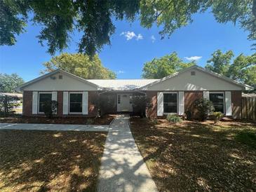 Charming brick home features a well-manicured lawn, tidy walkway, and lush foliage for great curb appeal at 330 W Wellington Dr, Lakeland, FL 33813