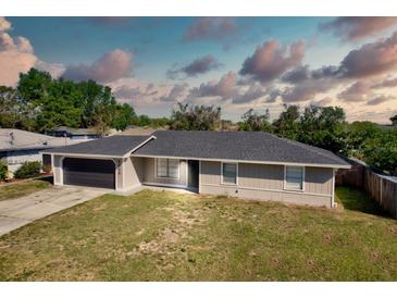 Charming single-story home with a gray exterior, updated roof, and an attached two-car garage at 4228 Sunny Land Dr, Lakeland, FL 33813