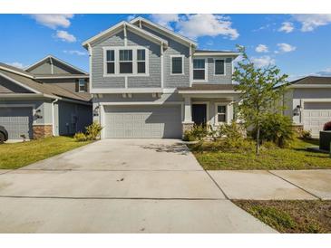 Charming two-story home featuring neutral gray siding, manicured lawn and an attached two-car garage at 728 Trotters Dr, Eagle Lake, FL 33839