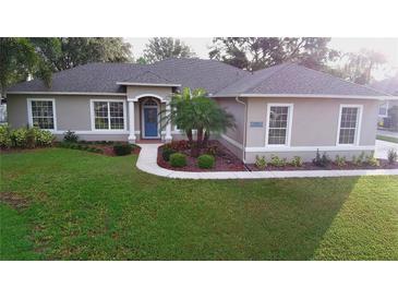 Charming single-story home featuring a manicured front lawn and beautiful landscaping at 10812 Versailles Blvd. Blvd, Clermont, FL 34711
