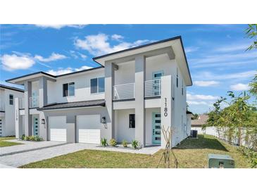 Modern two-story home with gray and white exterior, front lawn, light blue door, and a private balcony at 1180 Windjammer Dr, Lakeland, FL 33803