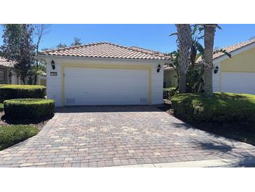 Charming home featuring a brick driveway, two car garage, and well manicured landscaping at 11953 Delfina Ln, Orlando, FL 32827