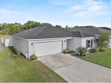 Charming single-story home with a two-car garage, well-manicured lawn, and lovely landscaping at 1341 Mattie Pointe Blvd, Auburndale, FL 33823