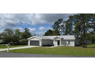 Charming single-story home featuring a well-maintained lawn and a two-car garage at 13650 Sw 43Rd Cir, Ocala, FL 34473