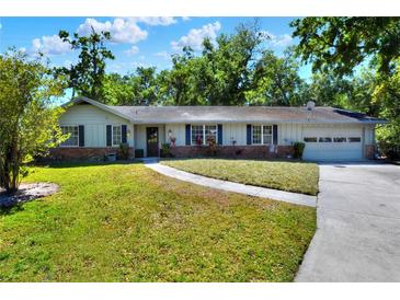 Charming single-story home featuring a well-maintained lawn, brick accents, and attached garage, perfect for suburban living at 1655 John Arthur Way, Lakeland, FL 33803