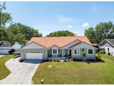 Charming single-story home boasts a well-manicured lawn, red roof, and attached two-car garage at 1931 Matthew Ct, Lakeland, FL 33813