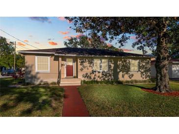 Charming single-story home boasting a well-maintained lawn, red brick walkway, and large shade tree at 2104 W End Ave, Lakeland, FL 33803