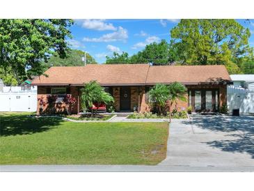 Charming single-story home with lush lawn, mature trees, and a well-maintained brick facade at 2329 Duff Rd, Lakeland, FL 33810
