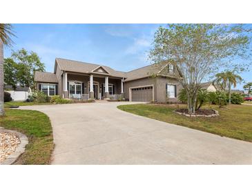 Beautiful home featuring manicured lawn, mature trees and a driveway leading to an attached garage at 2569 Colonel Ford Dr, Lakeland, FL 33813