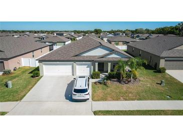 Inviting home featuring a three-car garage, well-manicured lawn, and a welcoming entrance at 2929 Flying Blackbird Rd, Bartow, FL 33830