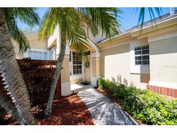Charming front entrance with a decorative wreath on the door and lush tropical landscaping at 3071 Shoal Creek Village Dr, Lakeland, FL 33803