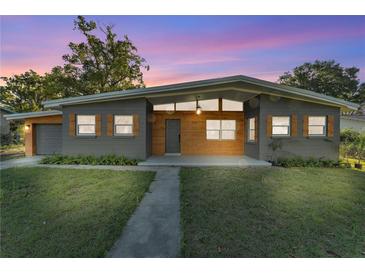 Charming single-story home featuring a modern exterior, natural wood accents, and well-manicured front yard at 3134 Hilltop S Ave, Lakeland, FL 33803