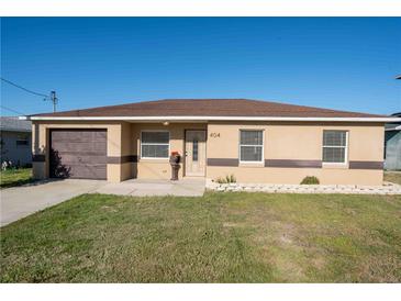 Charming single-story home featuring a well-maintained lawn and a cozy, inviting facade at 404 Red Hawk Loop, Winter Haven, FL 33880