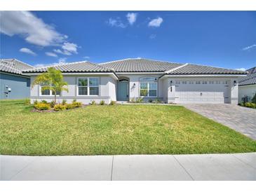 Charming single-story home featuring a manicured lawn, tiled roof, and a two-car garage at 4322 Juliana Lake Dr, Auburndale, FL 33823