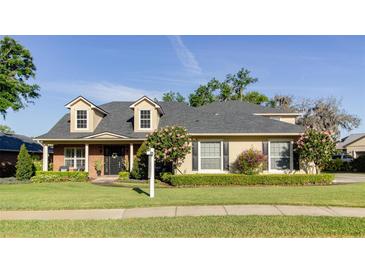 Charming two-story home featuring dormer windows, manicured lawn, and lush landscaping at 5789 Lake Victoria Dr, Lakeland, FL 33813