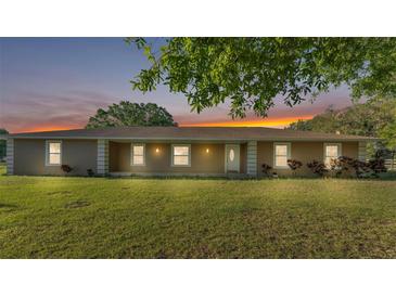 Charming single-story home featuring a large front yard and a welcoming entrance under a colorful twilight sky at 6981 Snell Rd, Bartow, FL 33830