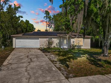 Charming single-story home with a two-car garage, solar panels, and a well-maintained front lawn at 7324 Thomas Jefferson E Cir, Bartow, FL 33830