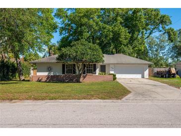 Charming single-story home featuring a brick facade, mature trees, and a well-maintained front yard with a cozy, inviting ambiance at 1116 Durham Dr, Lakeland, FL 33809