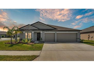 Charming single-story home featuring a well-manicured lawn, two-car garage, and neutral gray color scheme at 2983 Flying Blackbird Rd, Bartow, FL 33830