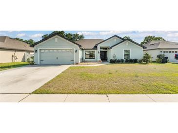 Charming single-story home with a well-manicured lawn and a two-car garage at 955 Hunters Meadow Ln, Lakeland, FL 33809