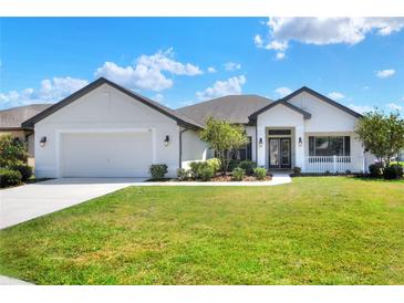 Charming single-story home featuring a manicured lawn and a welcoming front porch at 140 Heritage Park Ln, Mulberry, FL 33860