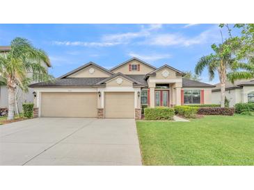 Attractive exterior with a well-manicured lawn, three-car garage, and lush landscaping at 1342 Heritage Landings Dr, Lakeland, FL 33805