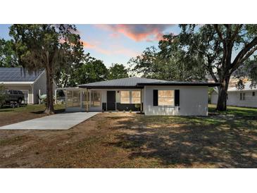 A charming home featuring a screened porch and new landscaping set against a tranquil evening sky at 1650 W Mcleod St, Bartow, FL 33830