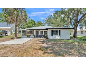 Charming single-story home with white facade, dark trim, and a welcoming screened-in porch at 1650 W Mcleod St, Bartow, FL 33830