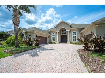 Stunning front exterior with lush landscaping, brick driveway, and a grand entrance, creating curb appeal at 715 Hanover Ct, Lakeland, FL 33813