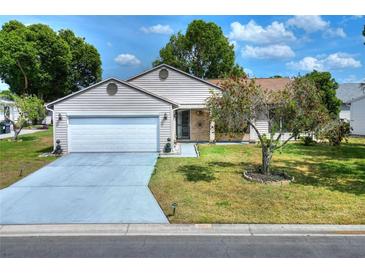 Charming single-story home featuring a well-maintained lawn, attached garage, and inviting curb appeal on a sunny day at 1010 Penguin Pl, Lakeland, FL 33809