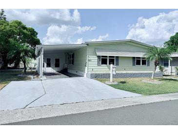 Inviting single-story home with carport, landscaped yard, and charming curb appeal at 1011 Pine Ridge Dr, Lakeland, FL 33809