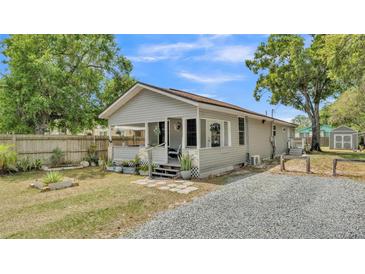 Charming single-story home featuring a cozy front porch, gray siding and gravel driveway at 1105 Terry S Ave, Lakeland, FL 33815