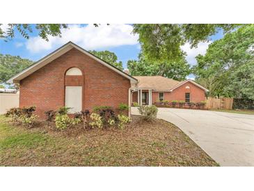 Charming single-story brick home with a well-maintained lawn and a curved driveway at 1205 Scottsland Dr, Lakeland, FL 33813