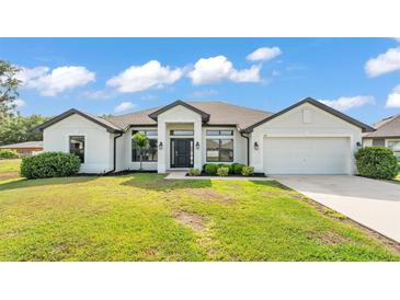 Beautiful single-story home featuring a well-manicured lawn and a two-car garage at 185 Heritage Park Ln, Mulberry, FL 33860