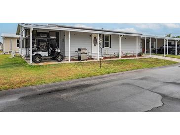 Charming single-story home with a well-maintained lawn, golf cart, and covered parking at 2055 S Floral Ave # 269, Bartow, FL 33830
