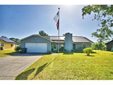 Beautiful single-Gathering home with lush green lawn, solar panels, and an American flag waving high at 2836 Magnolia Ave, Lakeland, FL 33812