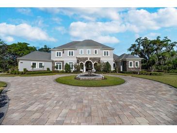 Stately two-story home with fountain, circular driveway, and beautifully landscaped front yard at 460 Canterwood Dr, Mulberry, FL 33860
