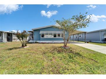 Cozy single-story home featuring a carport and landscaped front yard under a bright blue sky at 5015 Fox Cliff Dr, Lakeland, FL 33810
