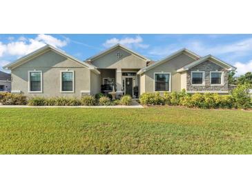Charming single story home with a well-manicured lawn and landscaped flower beds at 6372 English Creek Dr, Lakeland, FL 33811