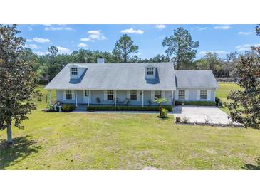 Charming single-story home featuring a well-manicured front lawn and classic dormer windows at 8337 Fussell Rd, Polk City, FL 33868