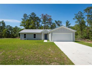 A well-manicured front lawn leads to a charming home with a two-car garage at 14385 Sw 39Th Court Rd, Ocala, FL 34473