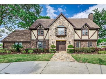 Charming two-story home with stone facade, detailed trim, and lush landscaping at 3906 Canyon Lake Pt, Lakeland, FL 33813