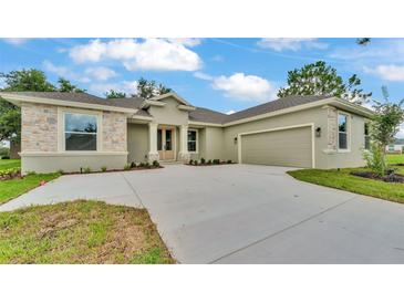 Charming single-story home with stone accents, a well-manicured lawn, and a spacious driveway leading to a two-car garage at 505 Shanklin Ave, Bartow, FL 33830