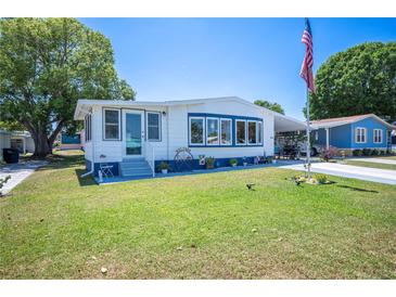 Charming single-story home with blue and white trim, lush lawn, and an American flag at 1506 Longbow Dr, Lakeland, FL 33810